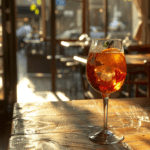 a glass of wine sitting on top of a wooden table